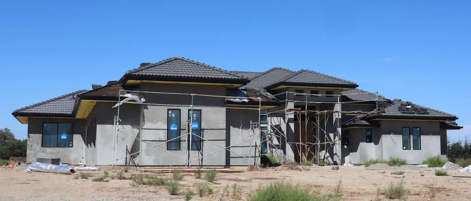 A new house in scaffolding with its stucco going on