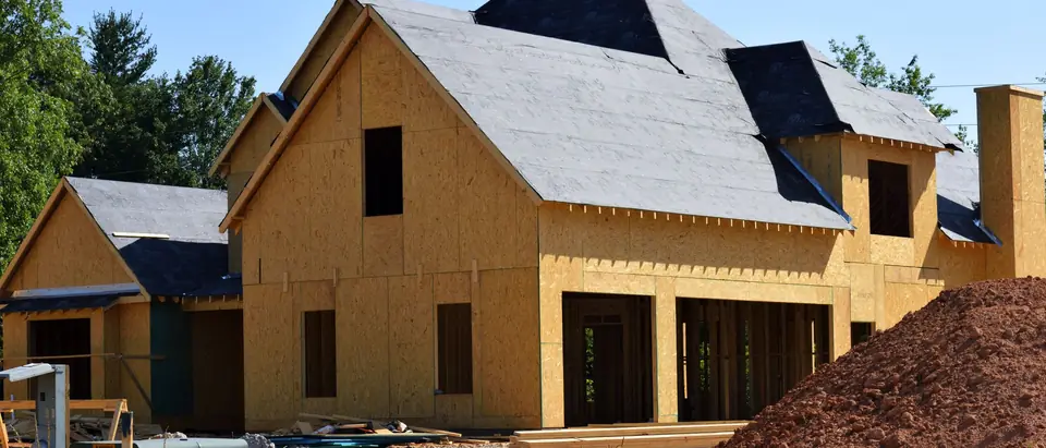 A new house sheathed and roofed, ready for siding