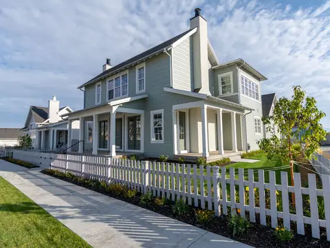 A new house with a white picket fence and a fresh lawn