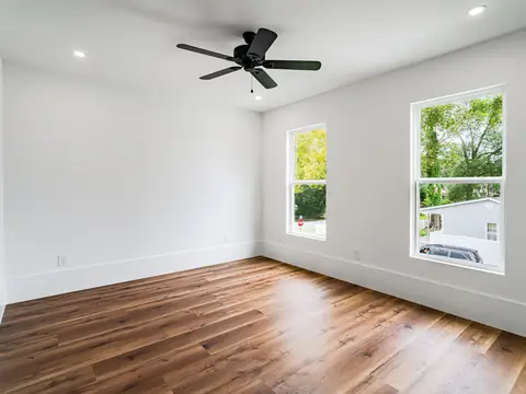 A freshly finished empty room with white walls and wood floors